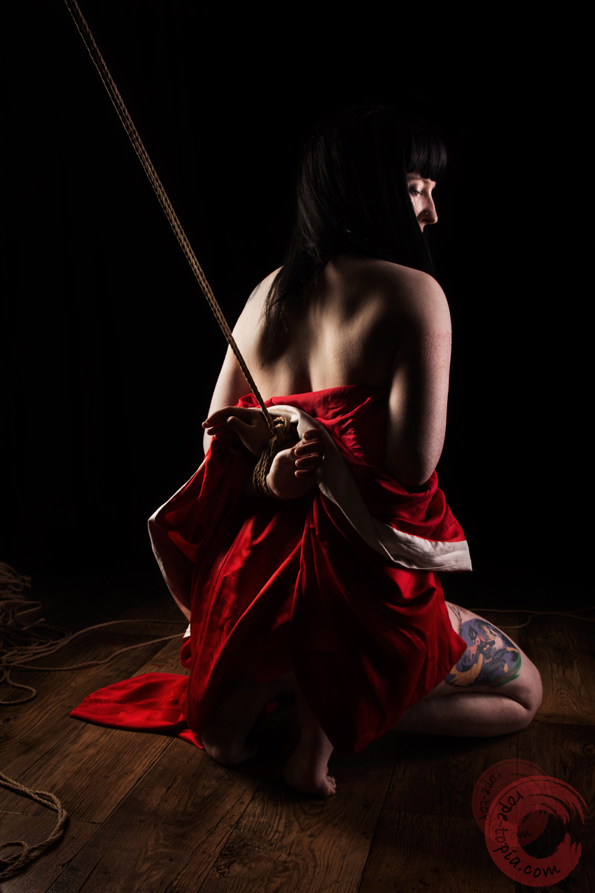 Shibari bondage emotion. Tattooed model tied in red juban. Bondage images by WykD Dave & Clover.